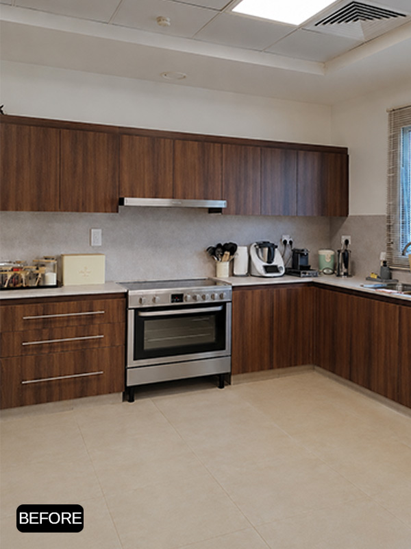 Kitchen before wrapping showing original dark wood cabinets in a Dubai residential apartment.