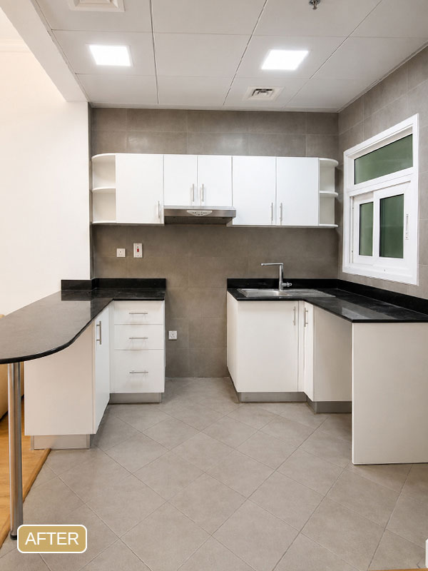 Kitchen after cabinet wrapping at Ayat Oasis, Dubai, featuring a modern matte white cabinet finish.